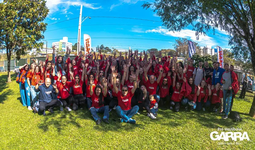 Dezenas de alunos do Garra reunidos ao ar livre com camisetas da escola