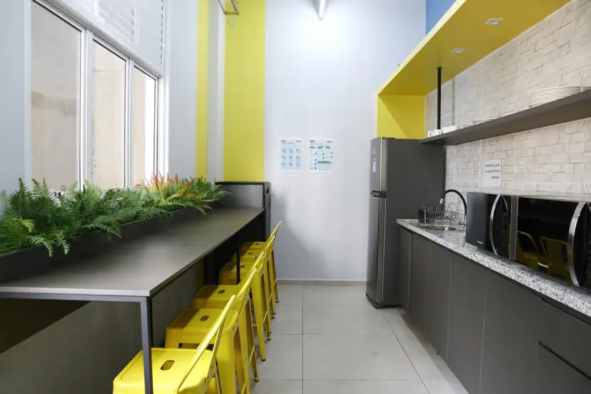 Cozinha e espaço de convivência com bancada e banquetas amarelas